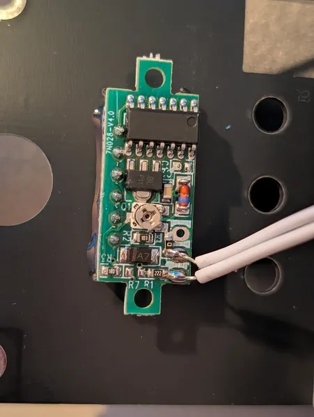 The green daughter board showing the DIP-8 IC, trimmer pot, SOT-23 transistor, and two white wires to the main board