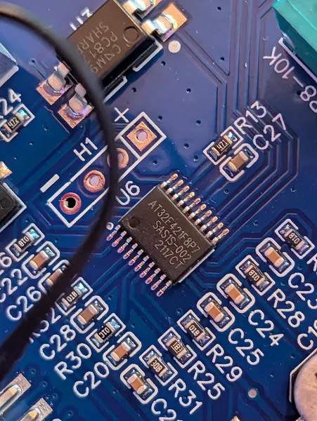 Close-up of the daughter board showing the AT32F421F8P7 MCU, the H1 SWD header pads, and the PC817 optocoupler