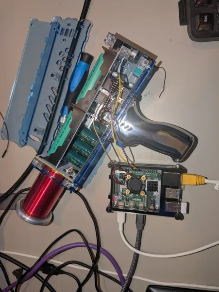 The open Tesla coil with capacitors visible alongside a Raspberry Pi 3B, wired together via GPIO jumper cables